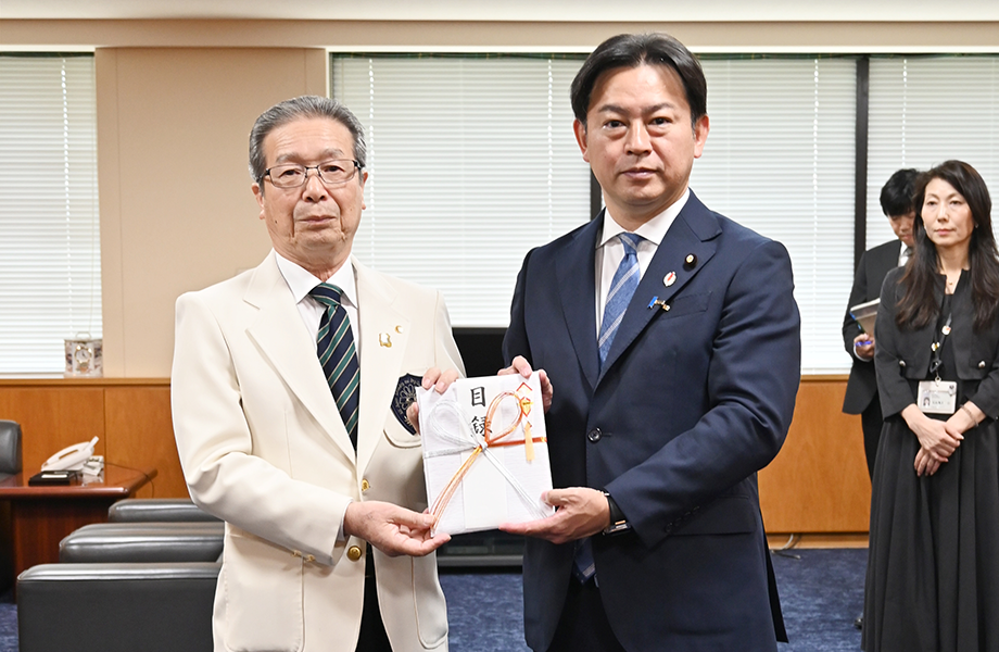 みのりの箱募金で福岡資麿厚生労働大臣に浄財の目録を渡す野澤会長